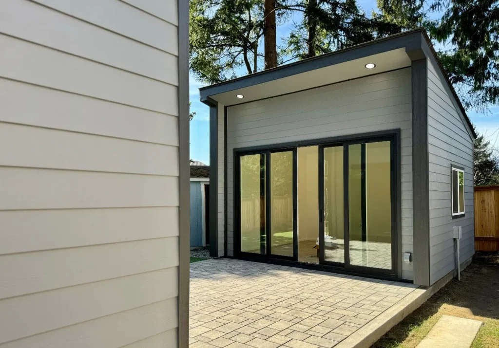 Modern backyard studio with full-glass sliding doors and paver patio