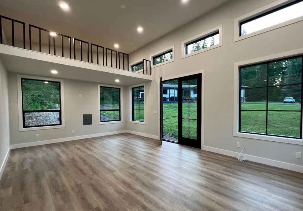 Backyard studio interior with loft, high ceiling and large windows