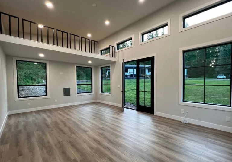 Backyard studio interior with loft, high ceiling and large windows