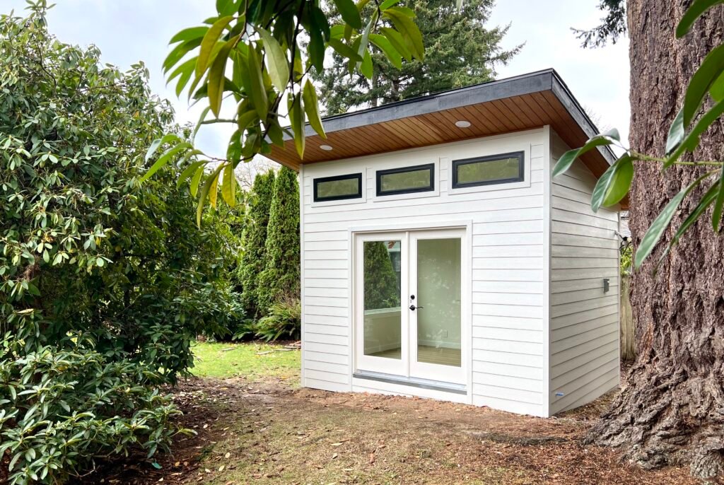 White tiny backyard office with French doors and clerestory windows
