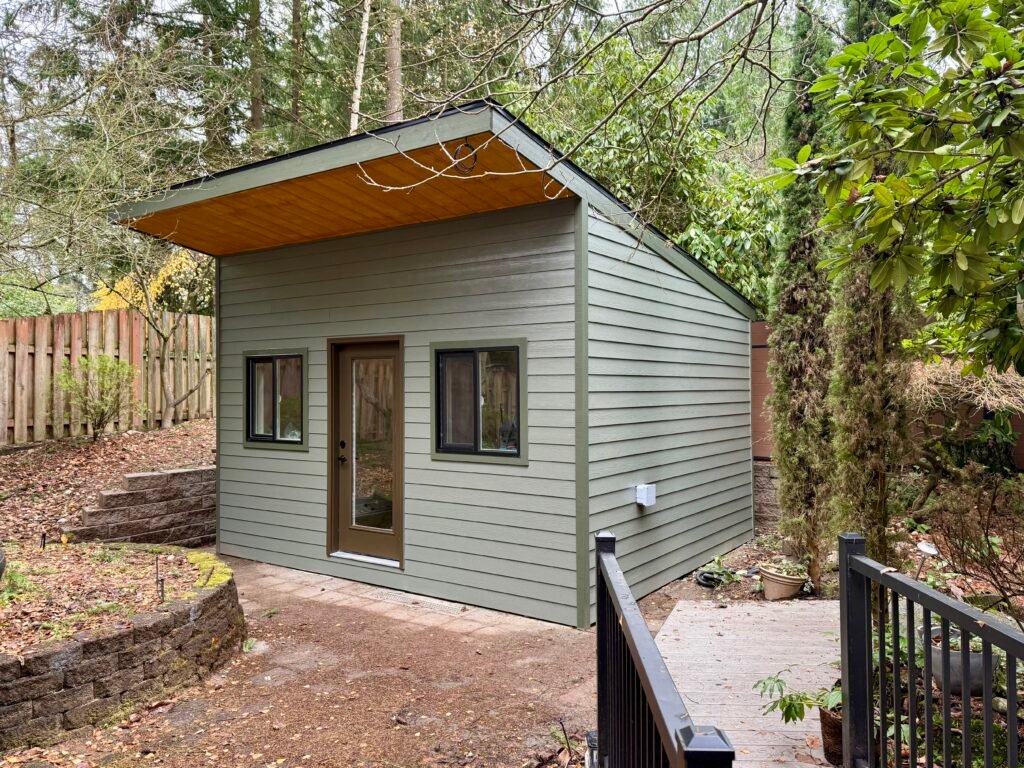 Green backyard workshop shed with a single-slope roof